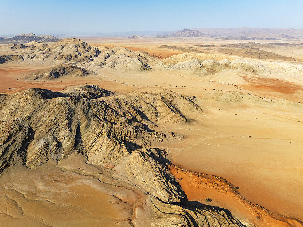 Arid plains, sand dunes and bare mountain ridges in the Tsondab Valley in the Namib Desert. Aerial view. Drone shot. Namibia.