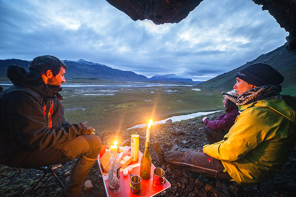 Candlelit meal at the entrance to the Puy Saint Theodule cave. To the left, Mont Alfred Grandidier. In the distance: Mont Blanc. Grande Terre, Kerguelen archipelago.