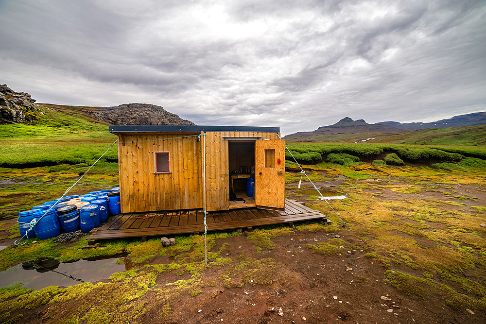 The Riviere du Nord hut. Composed of two small wooden modules solidly braced to the ground. One is the kitchen, the other the dormitory. Outside, cans contain enough food for a team of three or four scientists to live in for several weeks. Kerguelen Archipelago