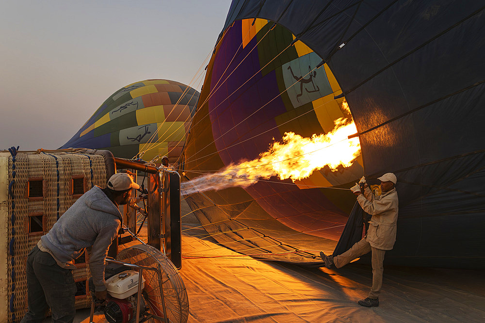 In order to get ready for the take-off, the pilot inflates the balloon with hot air by activating the burner. At dawn. Namib Desert, Kulala Wilderness Reserve, Namibia.