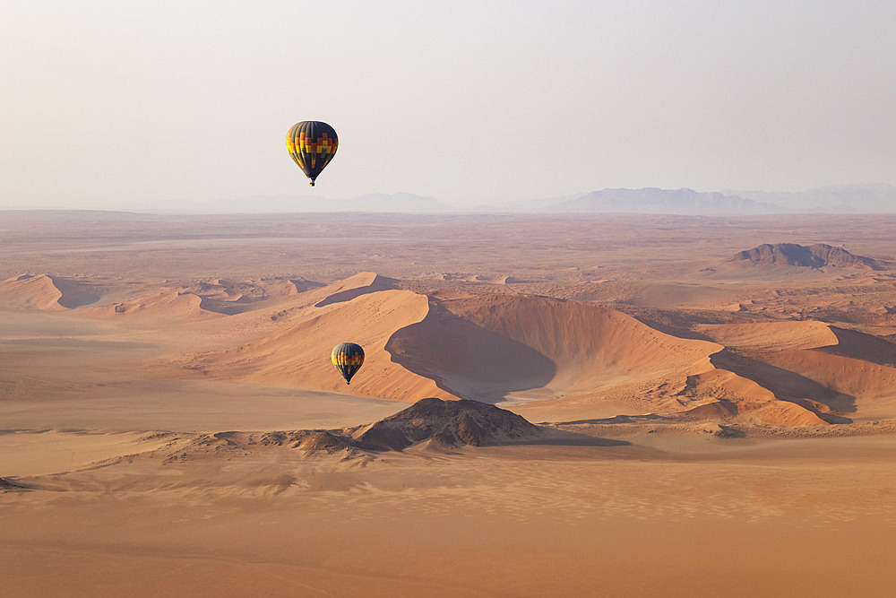 Two hot-air balloons at the edge of the Namib Desert. Aerial view from another balloon. Namibia.