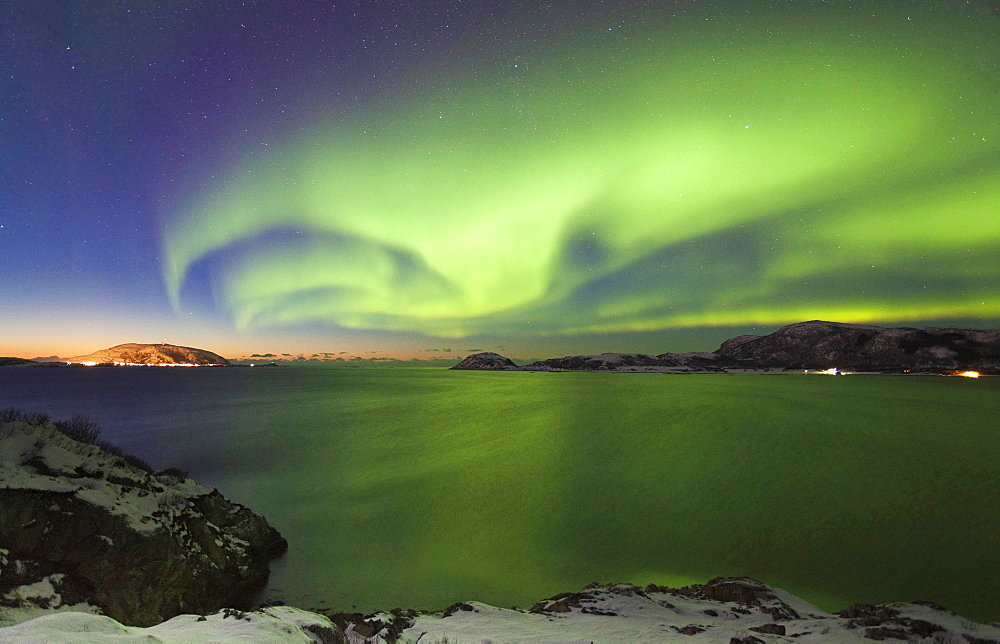 northern lights over landscape coast ocean sky with stars night shot Sandvika Troms Norwegen