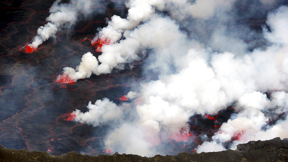 volcano Nyiragongo crater with lava fountains in the lava lake rising smoke nature natural phenomenon Kongo Afrika