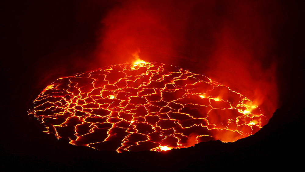 volcano Nyiragongo crater with lava fountains in the lava lake rising smoke nature natural phenomenon night view