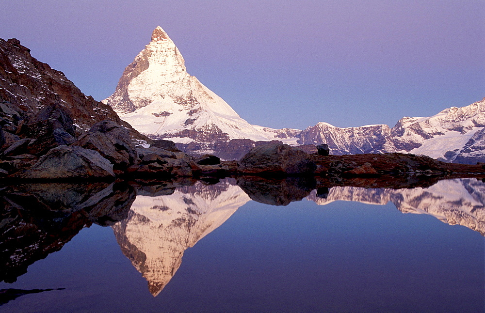 Matterhorn east face in evening light reflection in mountain lake