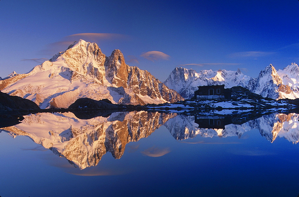 scenic view of rocky mountain peaks covered with snow and mountain hut with reflection in lake under blue sky outdoors horizontal format reflect reflecting reflections reflected sunlight sunlit Les Drus Les Aiguilles Lac Blanc near Chamonix French Alps France Europe