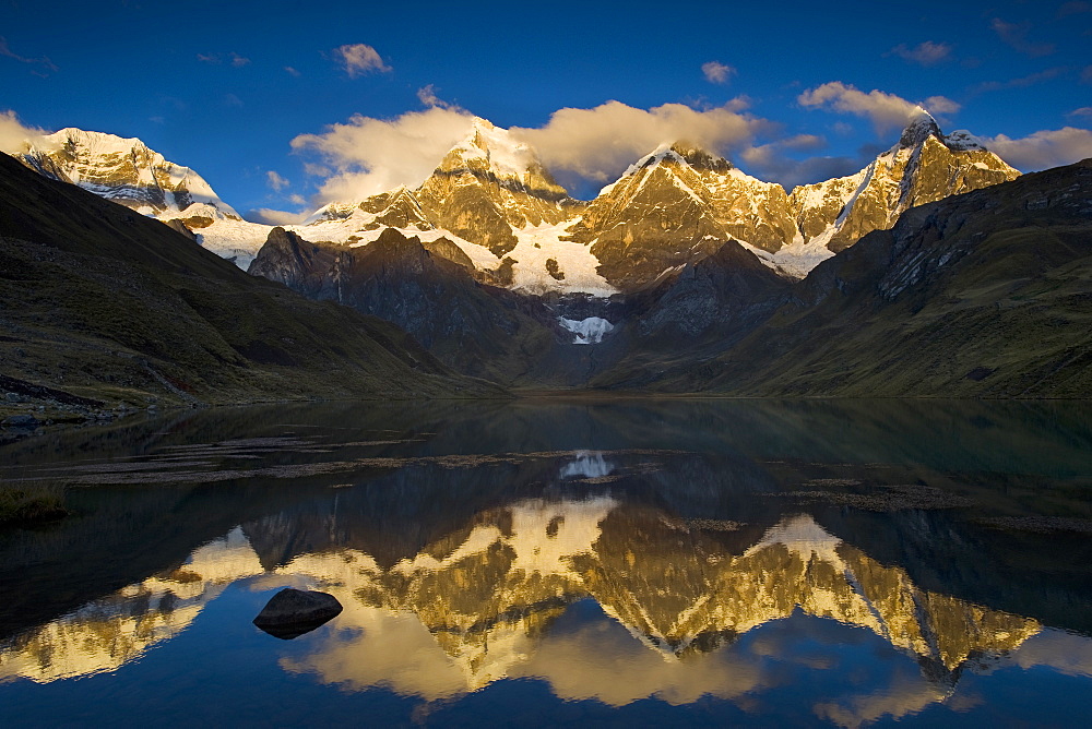 Andes mountains mountain Yerupaja 6635 m and Yerupaja Chico 6121 m partially covered with snow mountain lake in front with water surface reflection sunrise natural mood