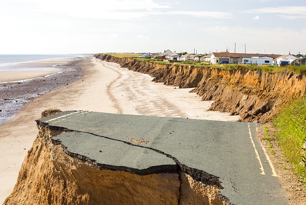 A collapsed coastal road at between Skipsea and Ulrome on Yorkshires East Coast, near Skipsea, UK. The coast is composed of soft boulder clays, very vulnerable to coastal erosion. This sectiion of coast has been eroding since Roman times, with many villages having disappeared into the sea, and is the fastest eroding coast in Europe. Climate change is speeding up the erosion, with sea level rise, increased stormy weather and increased heavy rainfall events, all palying their part.