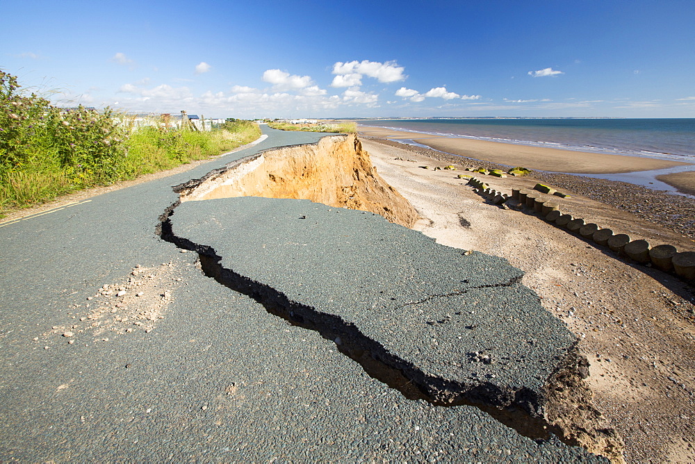 A collapsed coastal road at between Skipsea and Ulrome on Yorkshires East Coast, near Skipsea, UK. The coast is composed of soft boulder clays, very vulnerable to coastal erosion. This sectiion of coast has been eroding since Roman times, with many villages having disappeared into the sea, and is the fastest eroding coast in Europe. Climate change is speeding up the erosion, with sea level rise, increased stormy weather and increased heavy rainfall events, all palying their part.