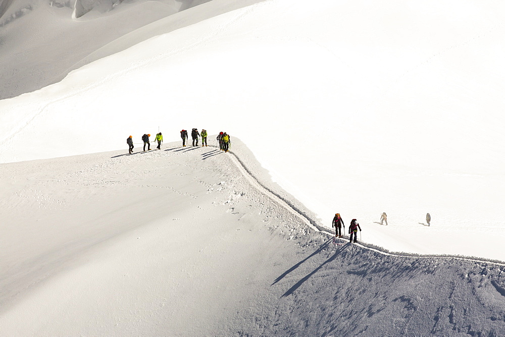 Climbers on the arete leading up from the Vallee Blanche to the Aiguille Du Midi above Chamonix, France.