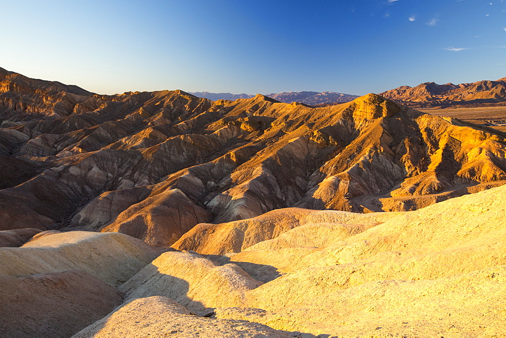 Badland scenery at sunset, Zabriskie Point in Death Valley which is the lowest, hottest, driest place in the USA, with an average annual rainfall of around 2 inches, some years it does not receive any rain at all.