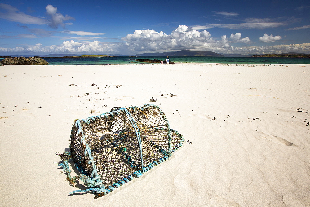 White sand beaches and clean seas on the north coast of Iona, off Mull, Scotland, UK, with a lobster pot washed ashore.