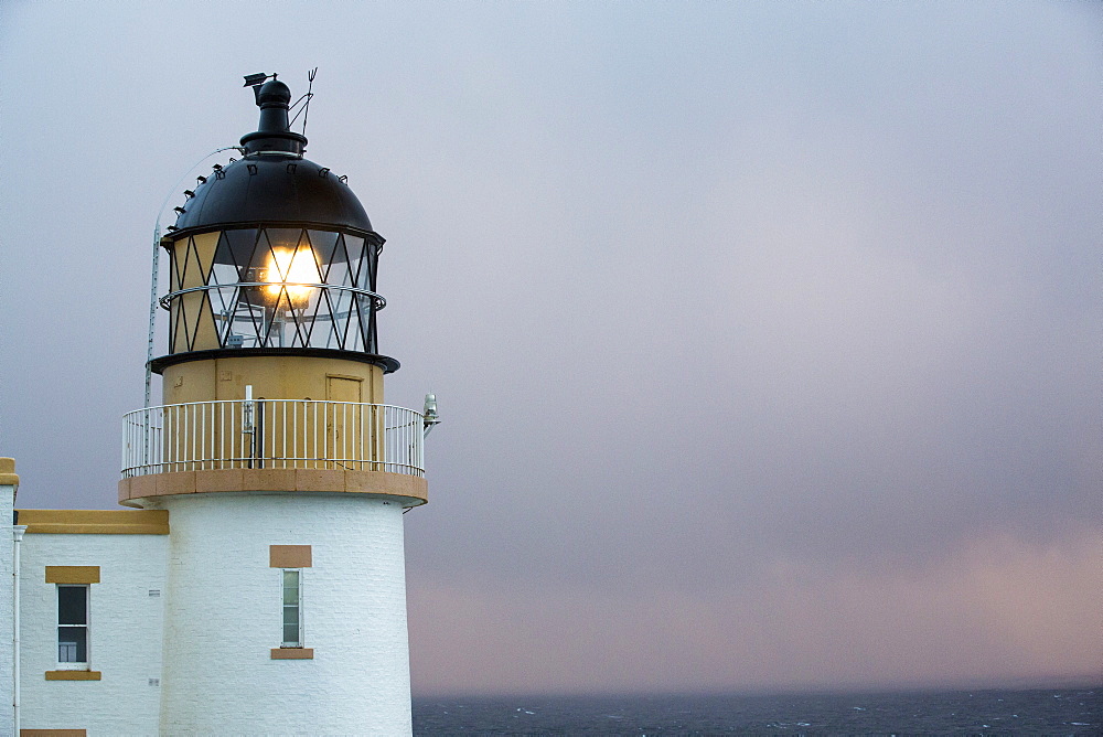 Rain showers at sunset over Stoer Point lighthouse in Assynt, North West Highlands, Scotland, UK.