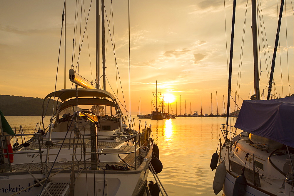 Yachts moored in the harbour in Sivota, Greece, at sunset,