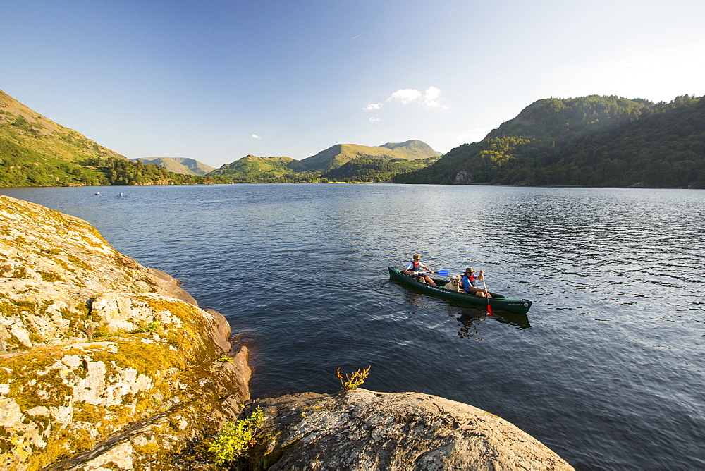 A family paddling in a Canadian Canoe on Ullswater in the Lake District, UK.