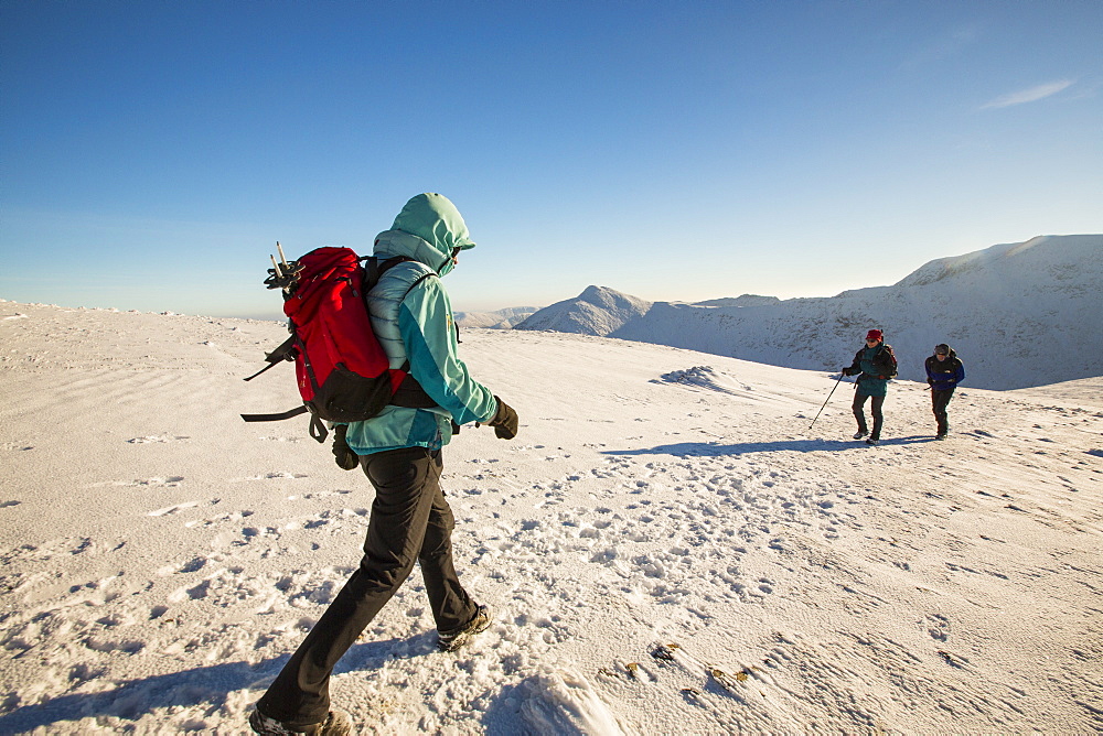 Walkers on the Helvellyn Range in winter conditions, Lake District, UK.