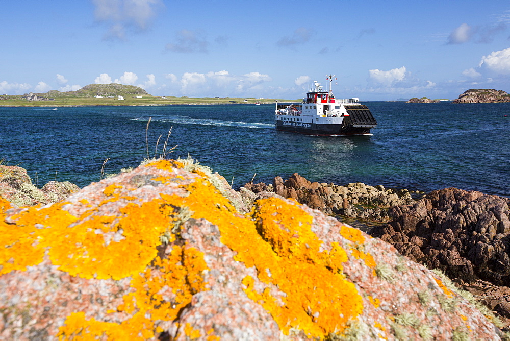 Lichen covered granite boulders at Fionnphort Isle of Mull, Scotland, UK, looking towards Iona, with the Iona ferry.