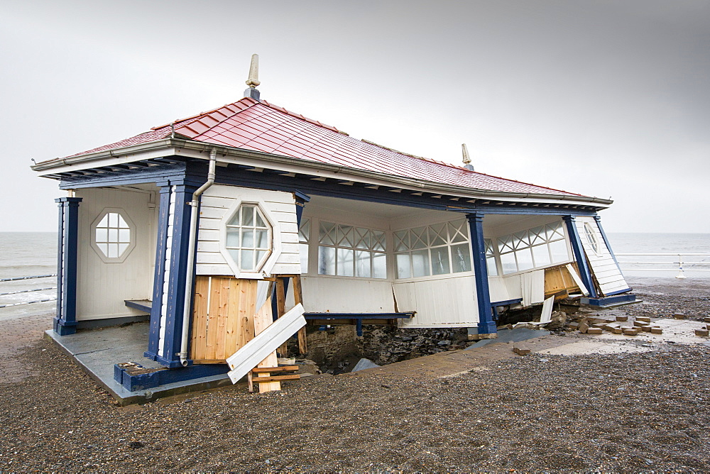 After a week of high tides, storm surges and storm force winds, the sea front promenade of Aberystwyth in Wales has been devastated, with millions of Â£'s of damage. The crsahing waves punched a large hole in the sea wall and has collapsed Aberystwyth's iconic, Victorian promenade shelter, which has stood for over 100 years. This picture was taken on Wednesday 8th January, 2014, the day the council started to try and clear the thousands of tonnes of beach rubble off the sea front road.