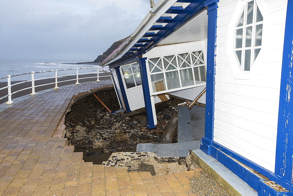 After a week of high tides, storm surges and storm force winds, the sea front promenade of Aberystwyth in Wales has been devastated, with millions of Â£'s of damage. The crsahing waves punched a large hole in the sea wall and has collapsed Aberystwyth's iconic, Victorian promenade shelter, which has stood for over 100 years. This picture was taken on Wednesday 8th January, 2014, the day the council started to try and clear the thousands of tonnes of beach rubble off the sea front road.