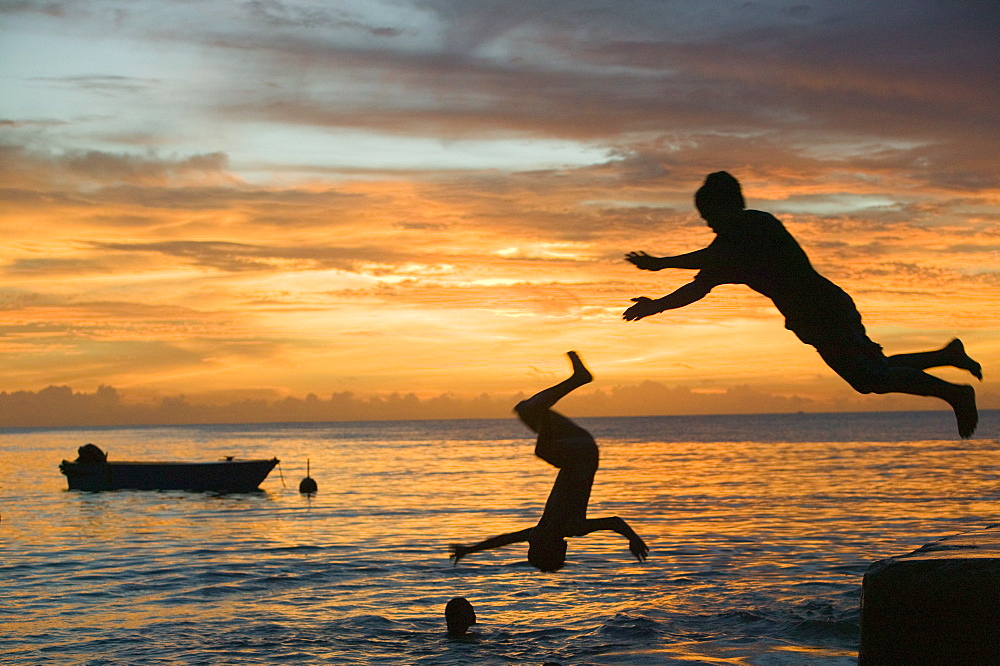 Tuvaluan children leaping into the sea on Funafuti Atoll, Tuvalu, Pacific