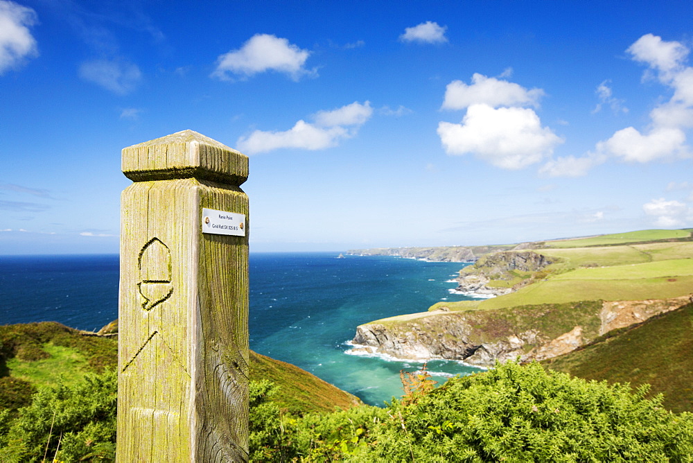 Coastal scenery on the South West Coast Path, East of Port Isaac, Cornwall, UK, with a path marker.