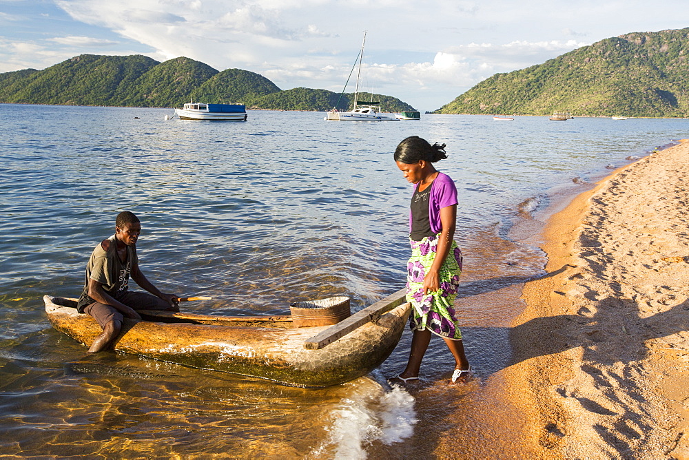 A fisherman in a traditional dug out canoe at Cape Maclear on the shores of Lake Malawi, Malawi, Africa.