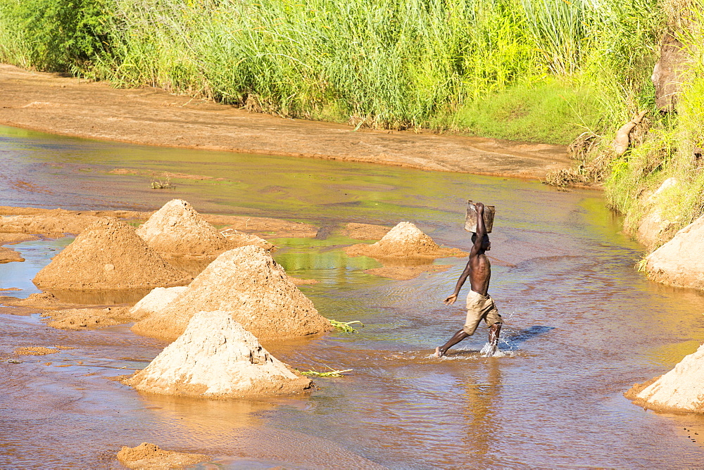 Workers extracting river sands and gravels from a river near Mangochi, Malawi, for use in house building.