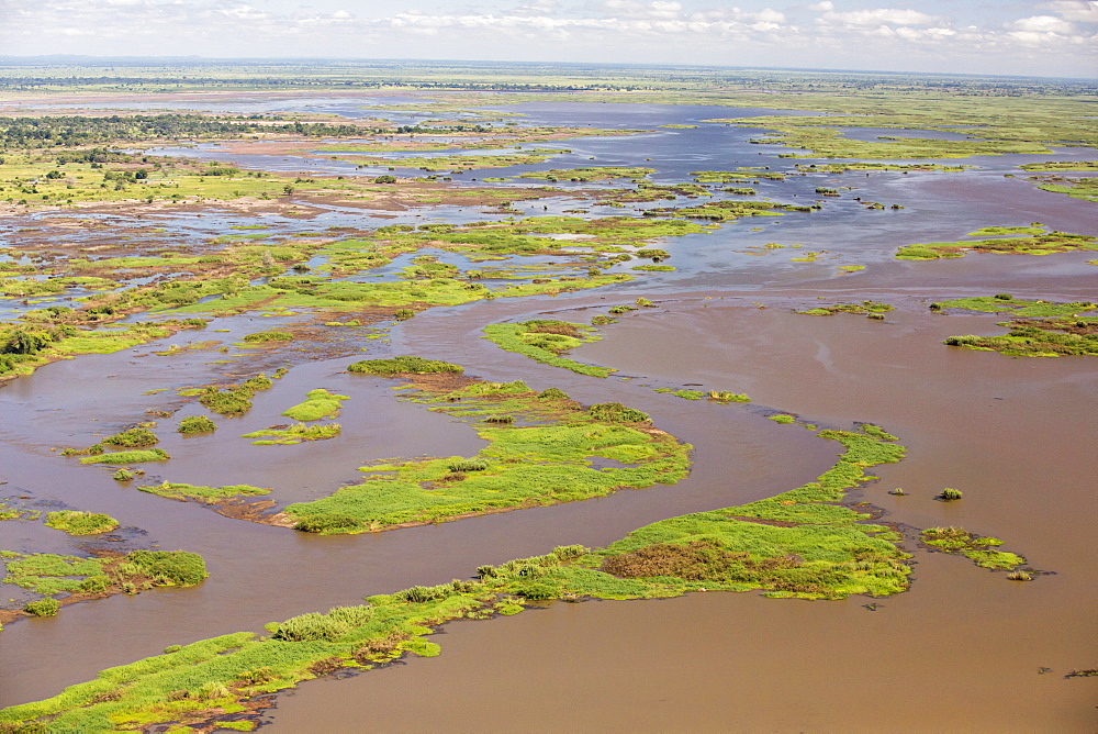 In mid January 2015, a three day period of excessive rain brought unprecedented floods to the small poor African country of Malawi. It displaced nearly quarter of a million people, devastated 64,000 hectares of land, and killed several hundred people. This shot taken from the air on a flight to Makhanga, which two months on, is still cut off by the floods when all rail and road connections were washed away, is looking down on the flood waters still sat on the flood plain.