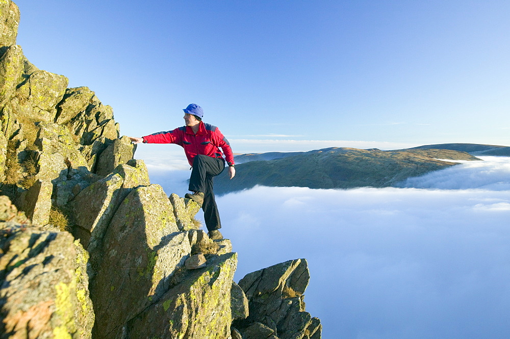 A climber on Red Screes above a temperature inversion in the Lake District National Park, Cumbria, England, United Kingdom, Europe