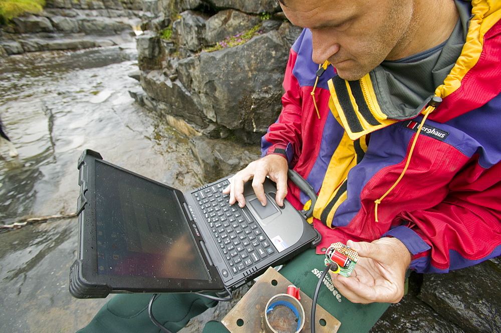 A scientist studying sediment load in a stream at Moorhouse in the north Pennines, Cumbria, England, United Kingdom, Europe