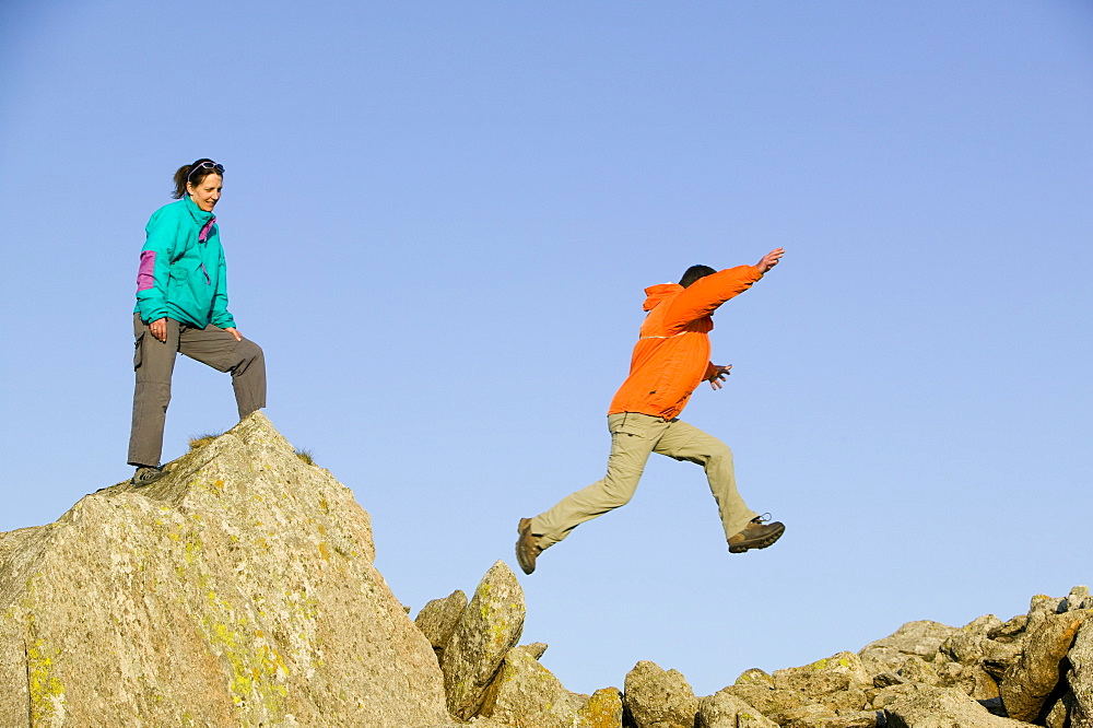 A man and women scrambling on Great Carrs in the Lake District National Park, Cumbria, England, United Kingdom, Europe