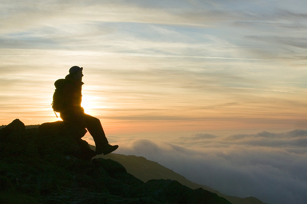 A walker above the clouds on Wet Side Edge in the Lake District National Park, Cumbria, England, United Kingdom, Europe