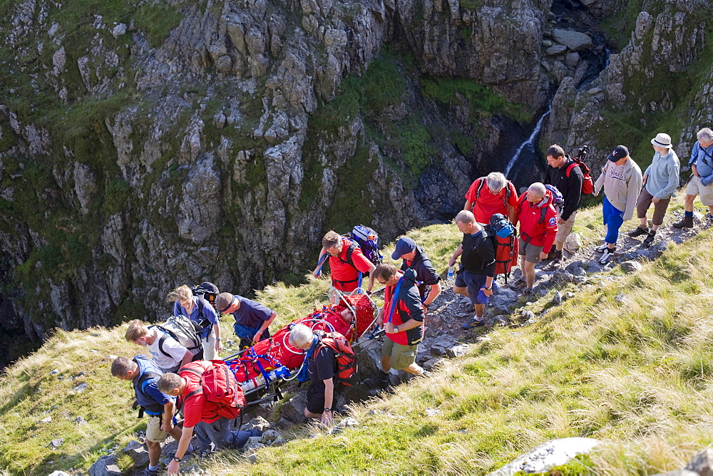 Members of Langdale Ambleside Mountain Rescue Team carrying an injured walker from the fells in Langdale, Cumbria, England, United Kingdom, Europe