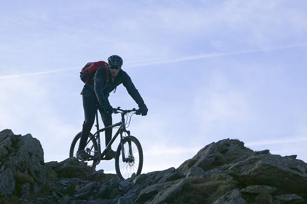 A mountain biker descending Helvellyn in the Lake District, Cumbria, England, United Kingdom, Europe