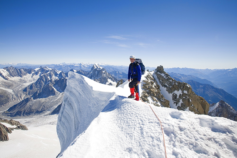 Climber on the summit of the 4000 metre peak of Mont Blanc Du Tacul above Chamonix, Haute Savoie, France, Europe