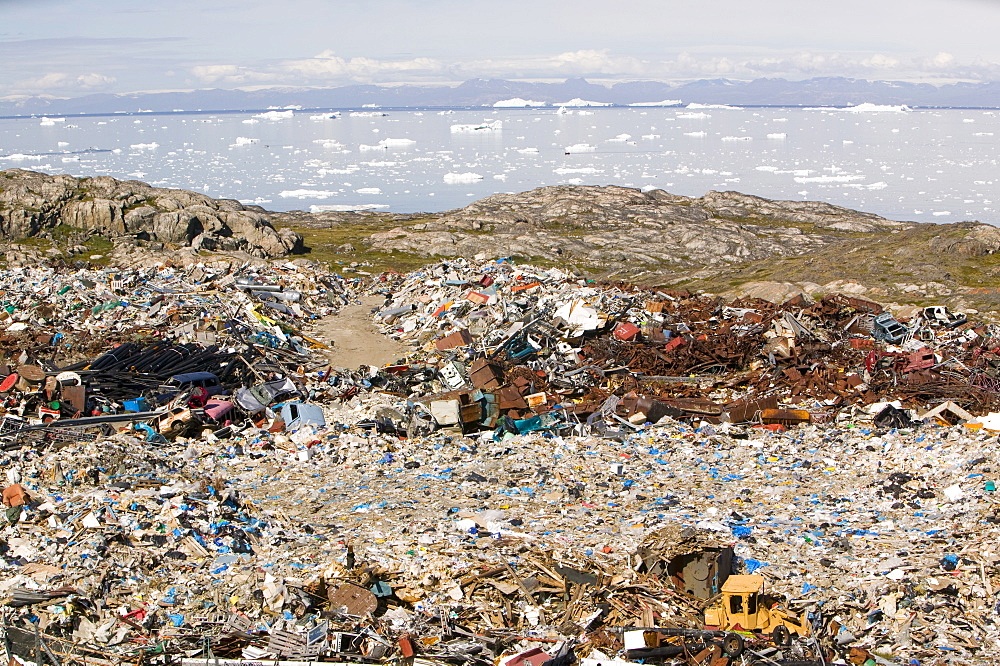 Rubbish dumped on the tundra outside Ilulissat in Greenland with icebergs behind from the Sermeq Kujalleq (Ilulissat Ice fjord), UNESCO World Heritage Site, Greenland, Polar Regions