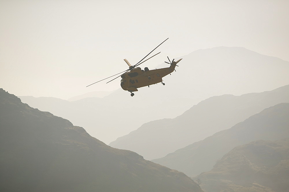 An RAF Sea King helicopter flying over the Langdale Valley in the Lake District, Cumbria, England, United Kingdom, Europe