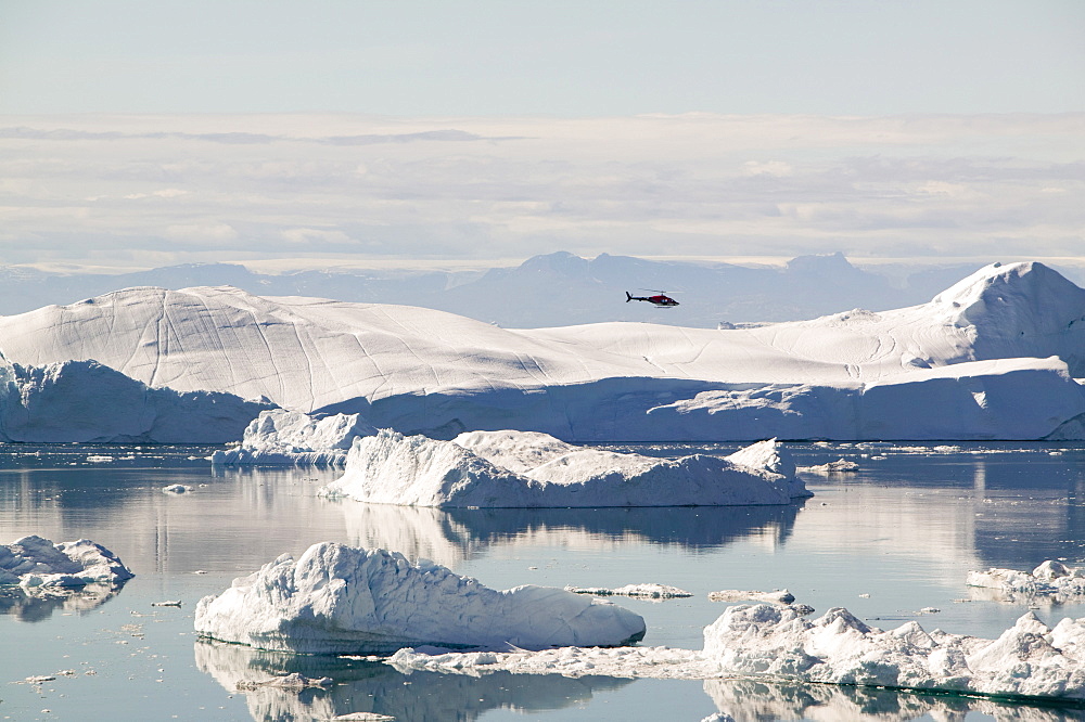 An Air Greenland helicopter flies over the Jacobshavn Glacier (Sermeq Kujalleq) that drains Greenland's ice sheet Greenland, Polar Regions