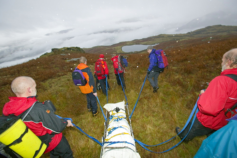 Members of Langdale Ambleside mountain rescue team remove the body of a heart attack victim from the fellside on Fairfield, Lake District, Cumbria, England, United Kingdom, Europe