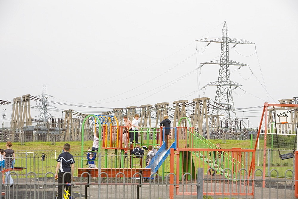 Children playing in front of an electricity plant and industrial complex in the town of Eston a suburb of Middlesbrough, Teesside, England, United Kingdom, Europe