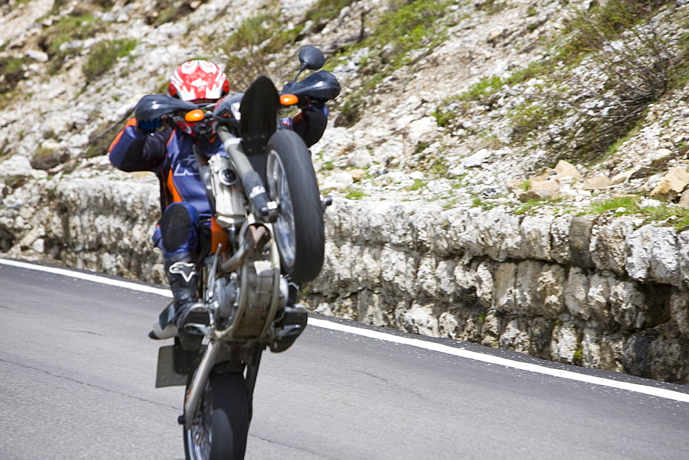 A motorcyclist showing off in the Italian Dolomites, Italy, Europe