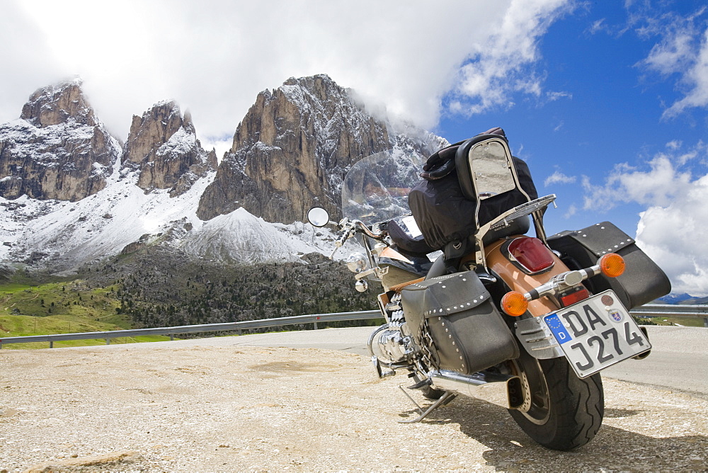 A motorbike on the summit of the Sella Joch pass in the Italian Dolomites with mountain view behind, Italy, Europe