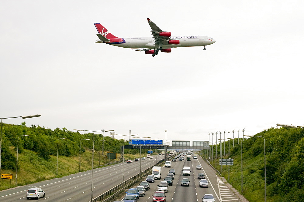 Traffic congestion on the M1 motorway and a plane coming in to land at East Midlands Airport, near Loughborough, Leicestershire, England, United Kingdom, Europe