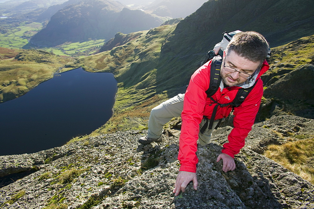 A man scrambling on Pavey Ark in the Lake District, Cumbria, England, United Kingdom, Europe