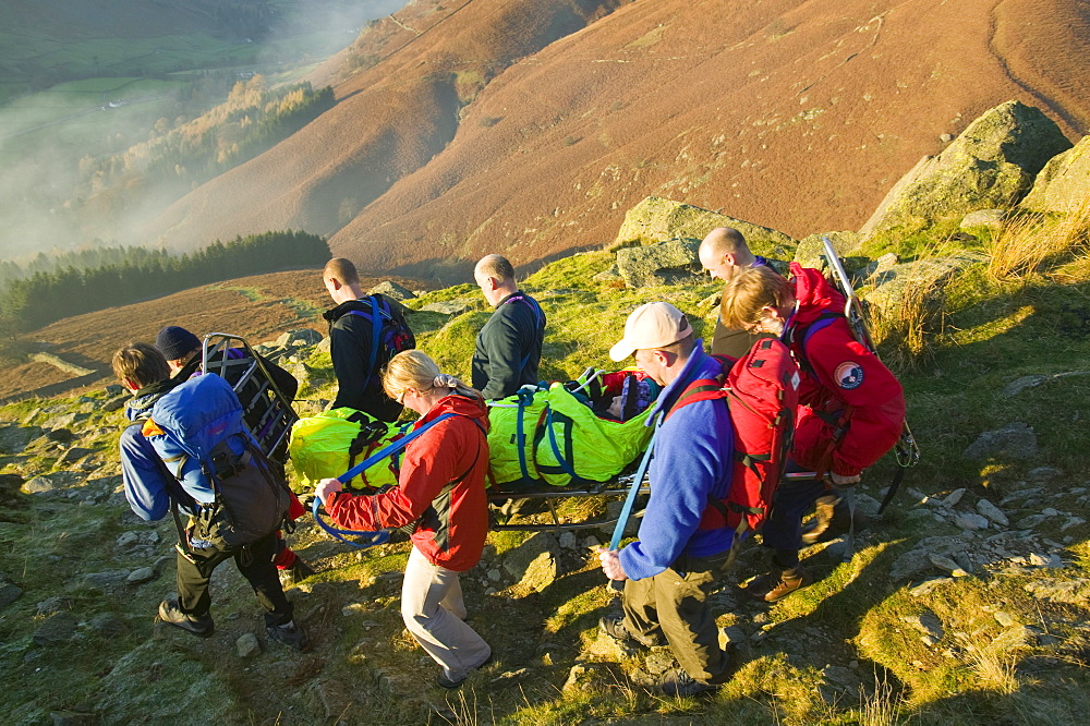 The Langdale Ambleside mountain Rescue Team stretcher an injured walker of the Lake District fells, Cumbria, England, United Kingdom, Europe