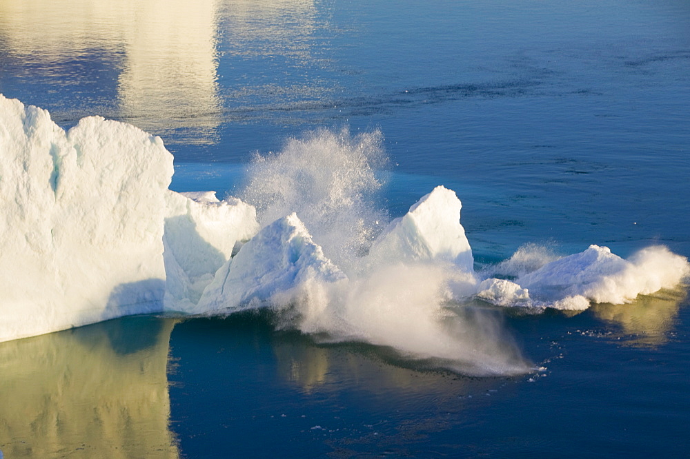 An arched iceberg collapsing into the sea from the Jacobshavn Glacier (Sermeq Kujalleq), Greenland, Polar Regions