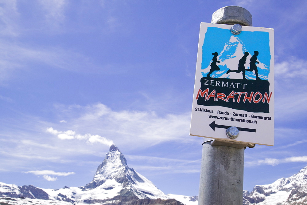 A sign for the Zermatt marathon in front of the Matterhorn above Zermatt, Switzerland, Europe