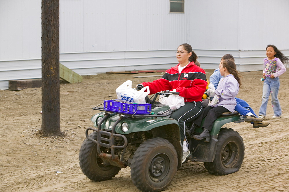 Woman and children on a quad bike on Shishmaref, a tiny island inhabited by around 600 Inuits, between Alaska and Siberia in the Chukchi Sea, United States of America, North America