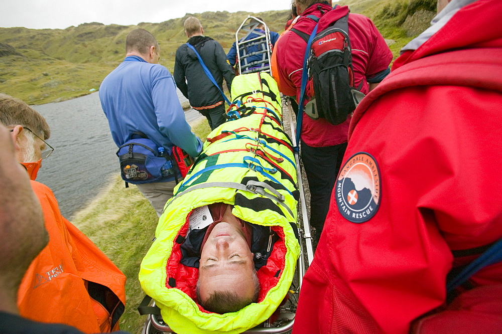 Langdale Ambleside Mountain Rescue Team stretcher an injured hiker off the Langdale Fells in the Lake District, Cumbria, England, United Kingdom, Europe