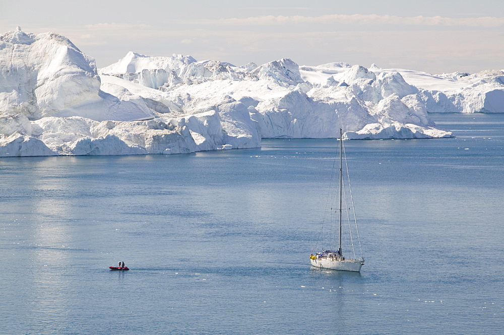 A French film crew documenting the effects of climate change sails their boat through icebergs from the Jacobshavn glacier (Sermeq Kujalleq), Greenland, Polar Regions